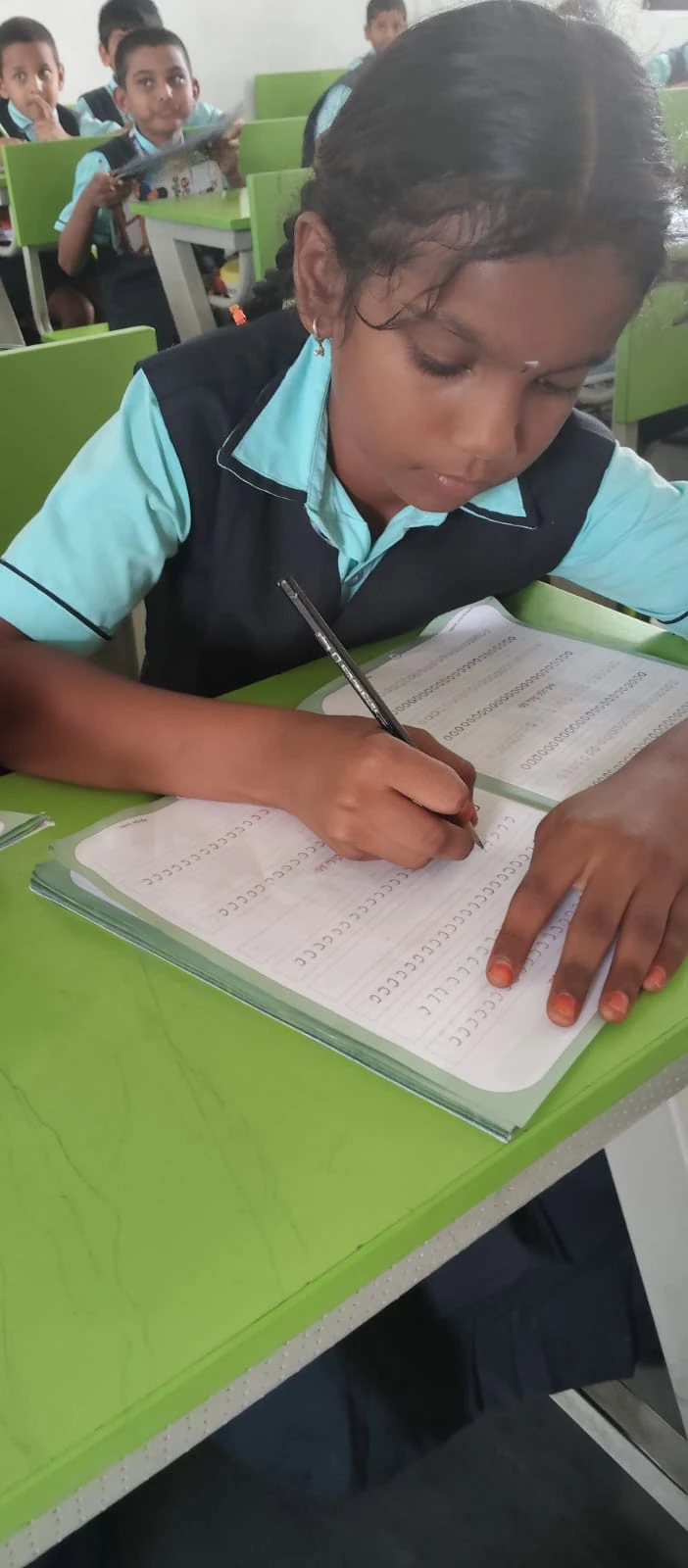 A student practising handwriting in the classroom