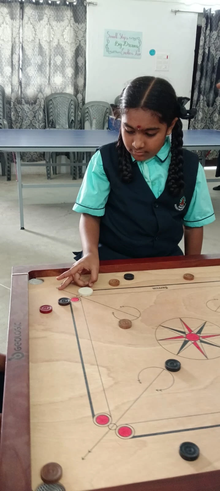 A student developing focus through carrom practice